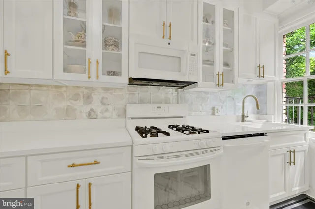 a white stove top oven sitting inside of a kitchen