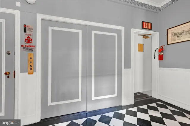 a walk in closet with wooden floor
