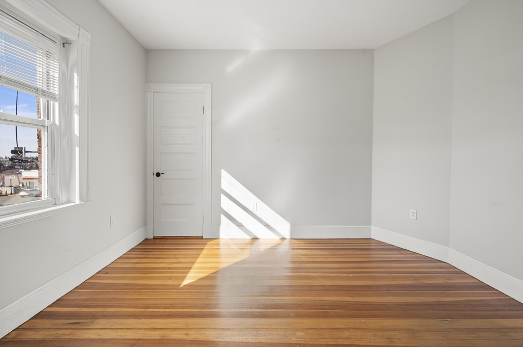 493 Broadway, Unit 2 Somerville, MA 02145 - Photo 16 of 24 a view of a room with wooden floor and staircase