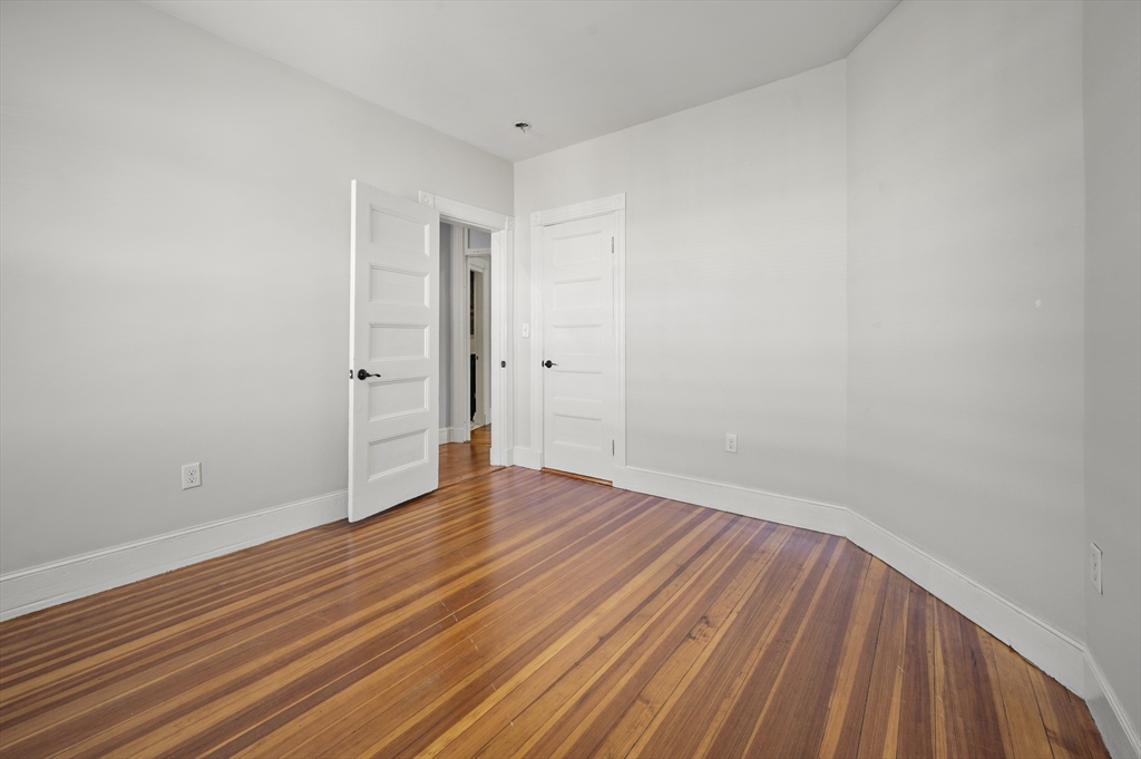 493 Broadway, Unit 2 Somerville, MA 02145 - Photo 21 of 24 a view of an empty room with wooden floor
