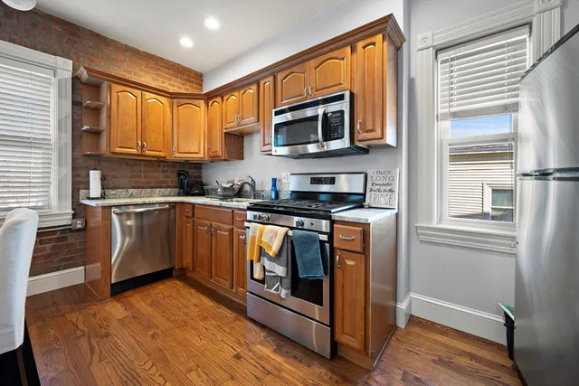 a kitchen with stainless steel appliances granite countertop a stove a sink and a microwave