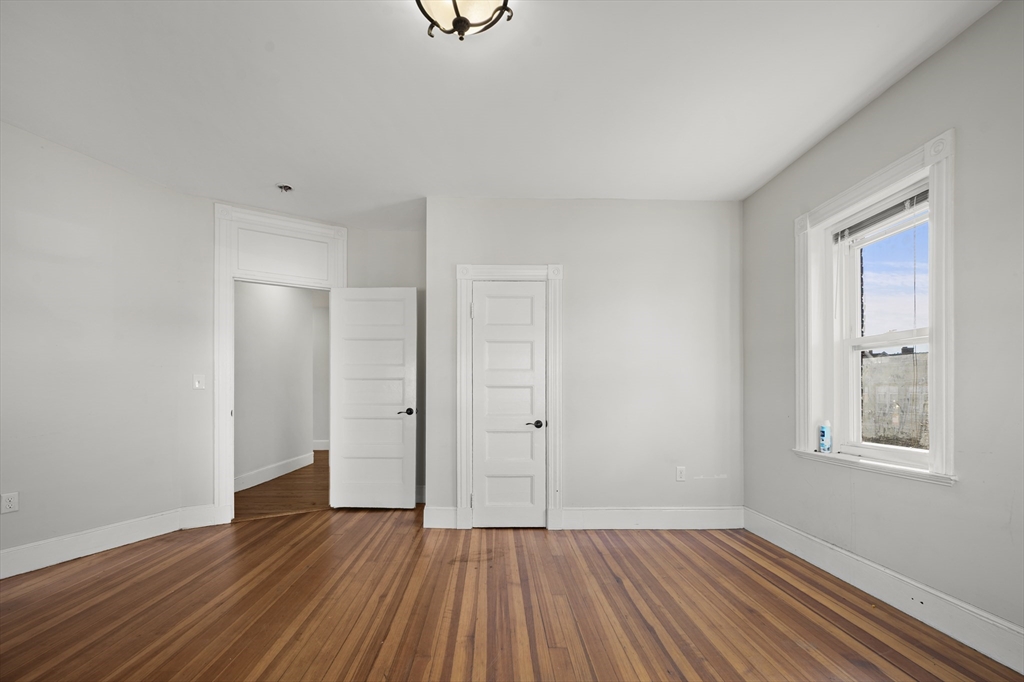 493 Broadway, Unit 2 Somerville, MA 02145 - Photo 8 of 24 a view of an empty room with wooden floor and a window