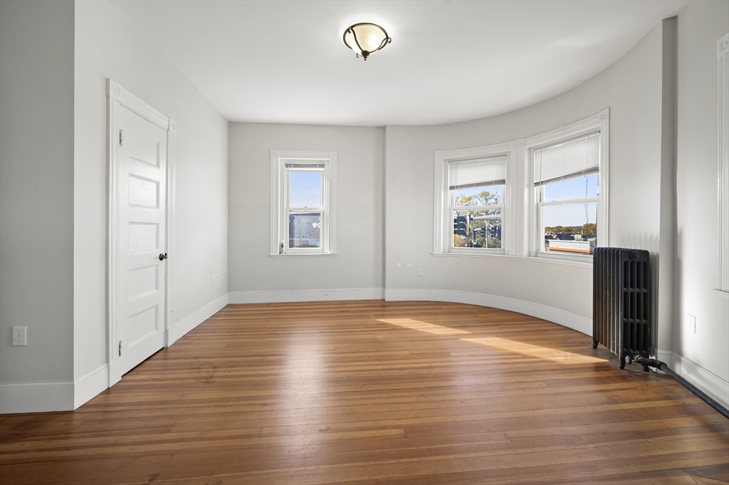 493 Broadway, Unit 2 Somerville, MA 02145 - Photo 9 of 24 a view of empty room with wooden floor and fan