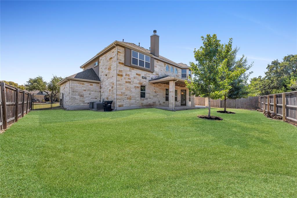 110 Magona Trail Georgetown, TX 78628 - Photo 37 of 38 A spacious, well-maintained yard provides a serene backdrop for this stone-clad residence.