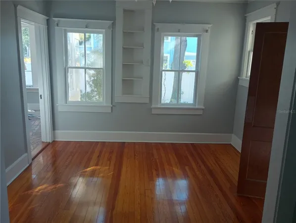 a view of a room with wooden floor and window
