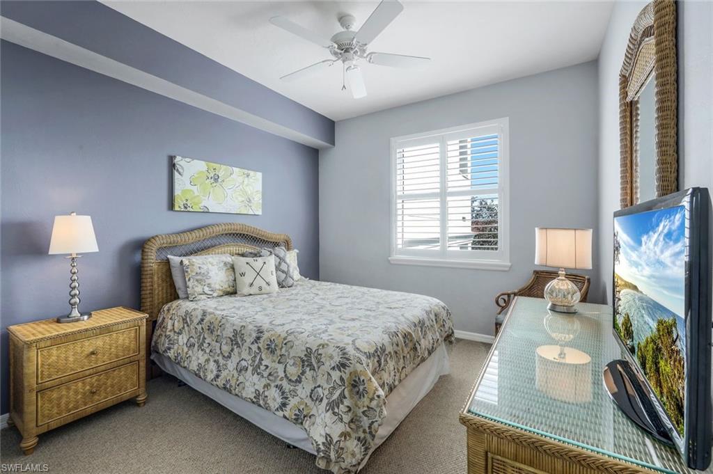 460 Launch Circle, Unit 401 Naples, FL 34108 - Photo 12 of 24 a bedroom with bed and a flat tv screen on dresser