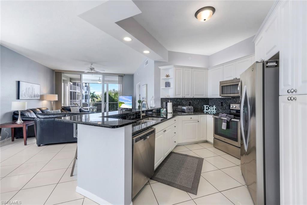 460 Launch Circle, Unit 401 Naples, FL 34108 - Photo 4 of 24 a kitchen with stainless steel appliances granite countertop a sink and cabinets