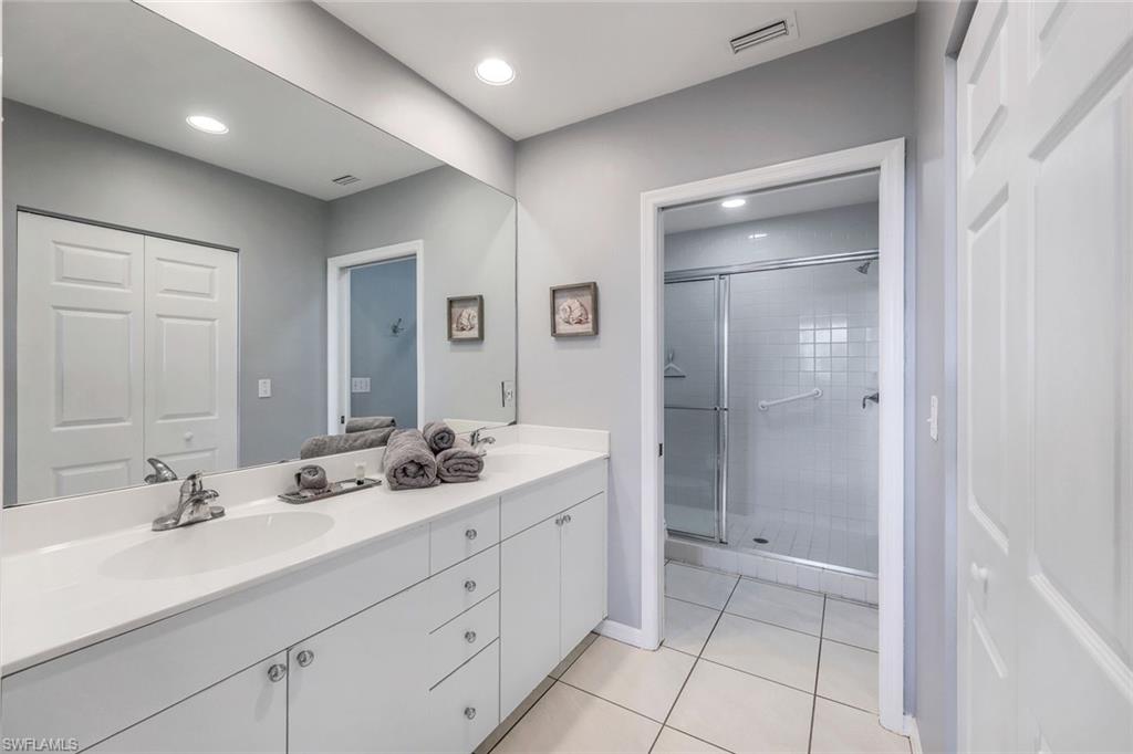 460 Launch Circle, Unit 401 Naples, FL 34108 - Photo 8 of 24 a bathroom with a double vanity sink mirror and shower