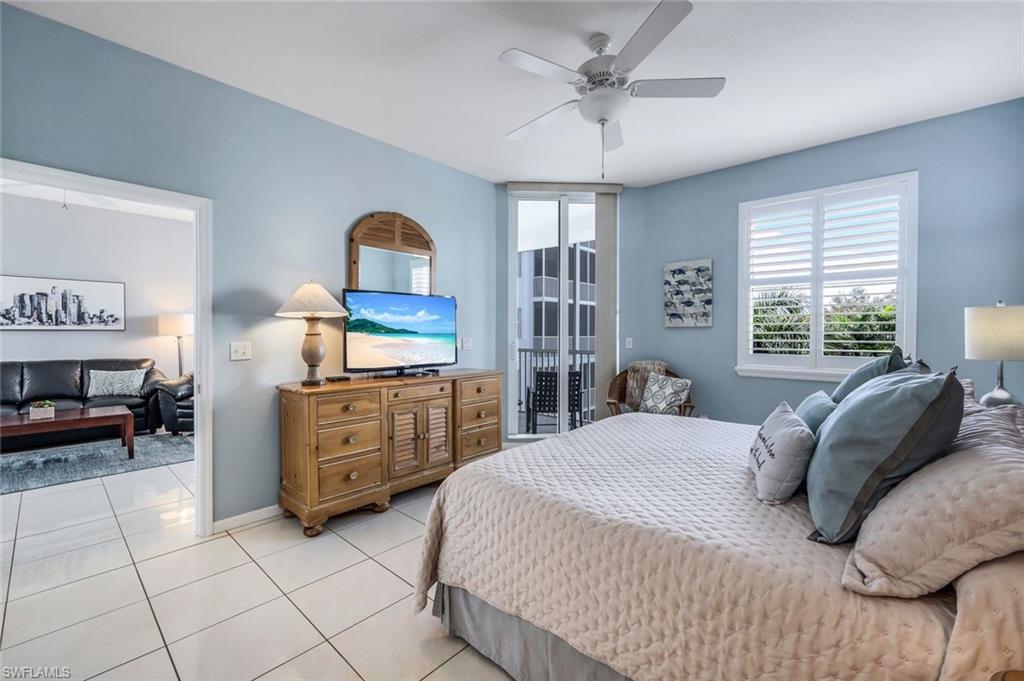 460 Launch Circle, Unit 401 Naples, FL 34108 - Photo 9 of 24 a bedroom with a bed and a dresser in it