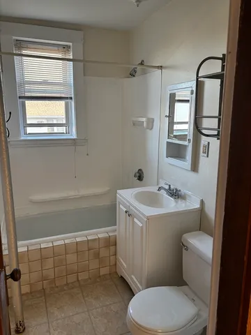a bathroom with a sink toilet and window