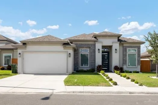 a front view of a house with a garden and plants