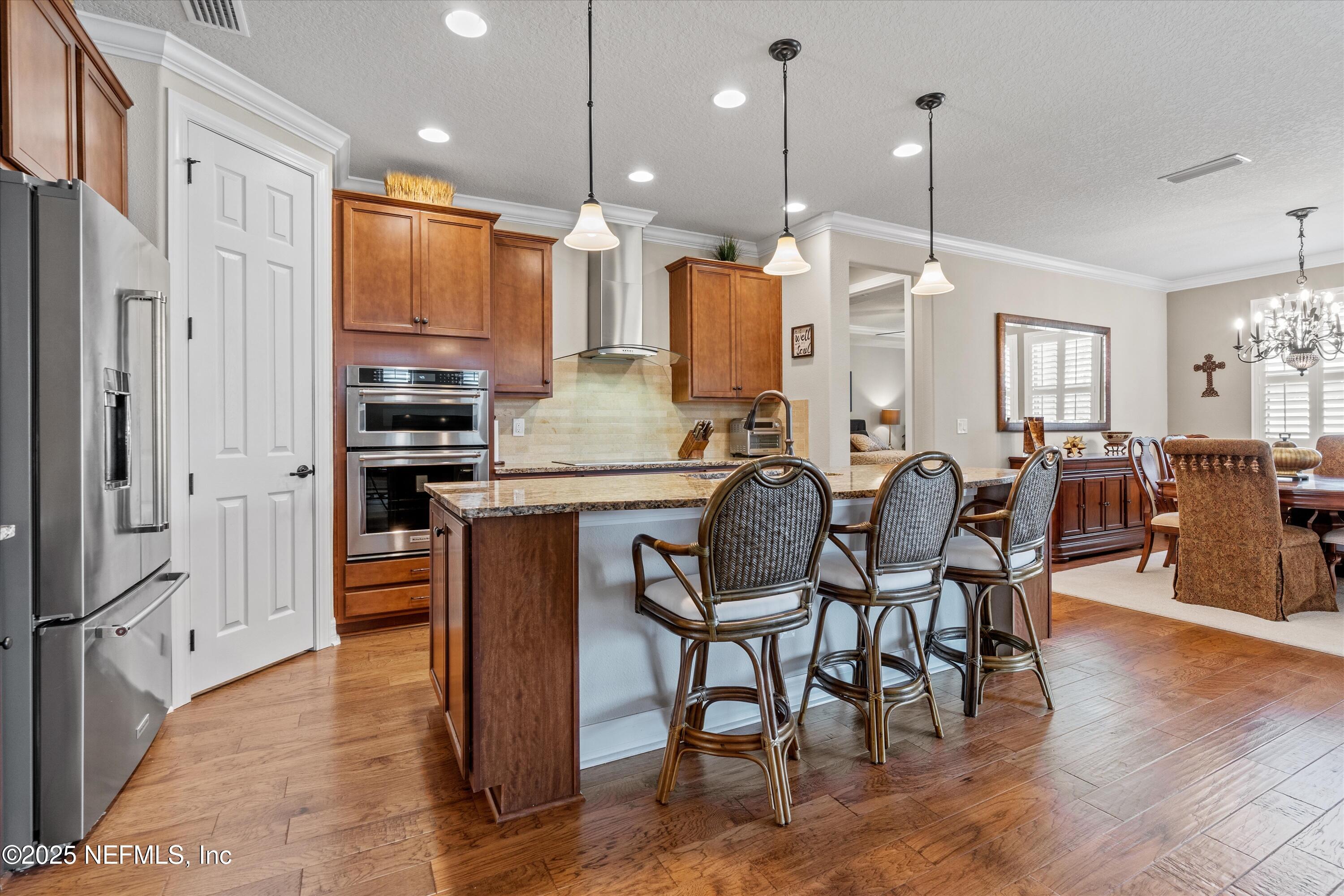440 Winding Path Drive Ponte Vedra, FL 32081 - Photo 14 of 35 a kitchen with stainless steel appliances kitchen island granite countertop a table chairs and a refrigerator