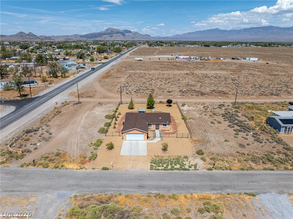 2970 Rio Rico Drive Pahrump, NV 89048 - Photo 36 of 41 An aerial perspective showcases a single-story residence nestled within a vast desert landscape with distant mountains.