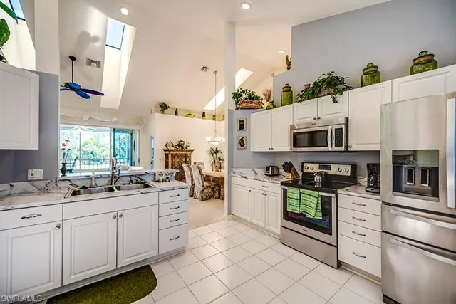 a kitchen with white cabinets and appliances