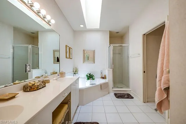 a bathroom with a sink a potted plant and a large mirror