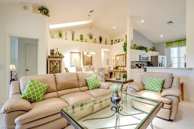 a living room with furniture kitchen view and a chandelier