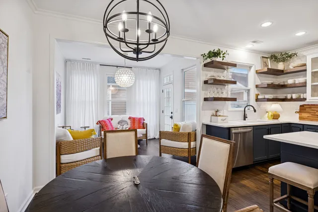 a kitchen with a refrigerator a stove a sink dishwasher with a dining table and chairs