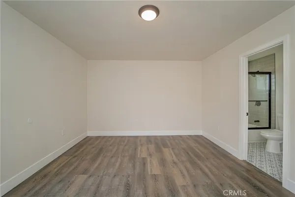 a view of a room with wooden floor and mirror