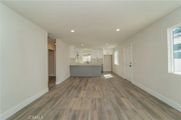 a view of a big room with wooden floor and windows