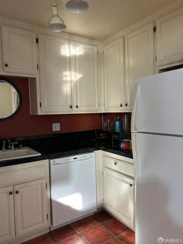 a kitchen with a sink a refrigerator and cabinets