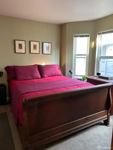 a bed sitting in a bedroom next to a window
