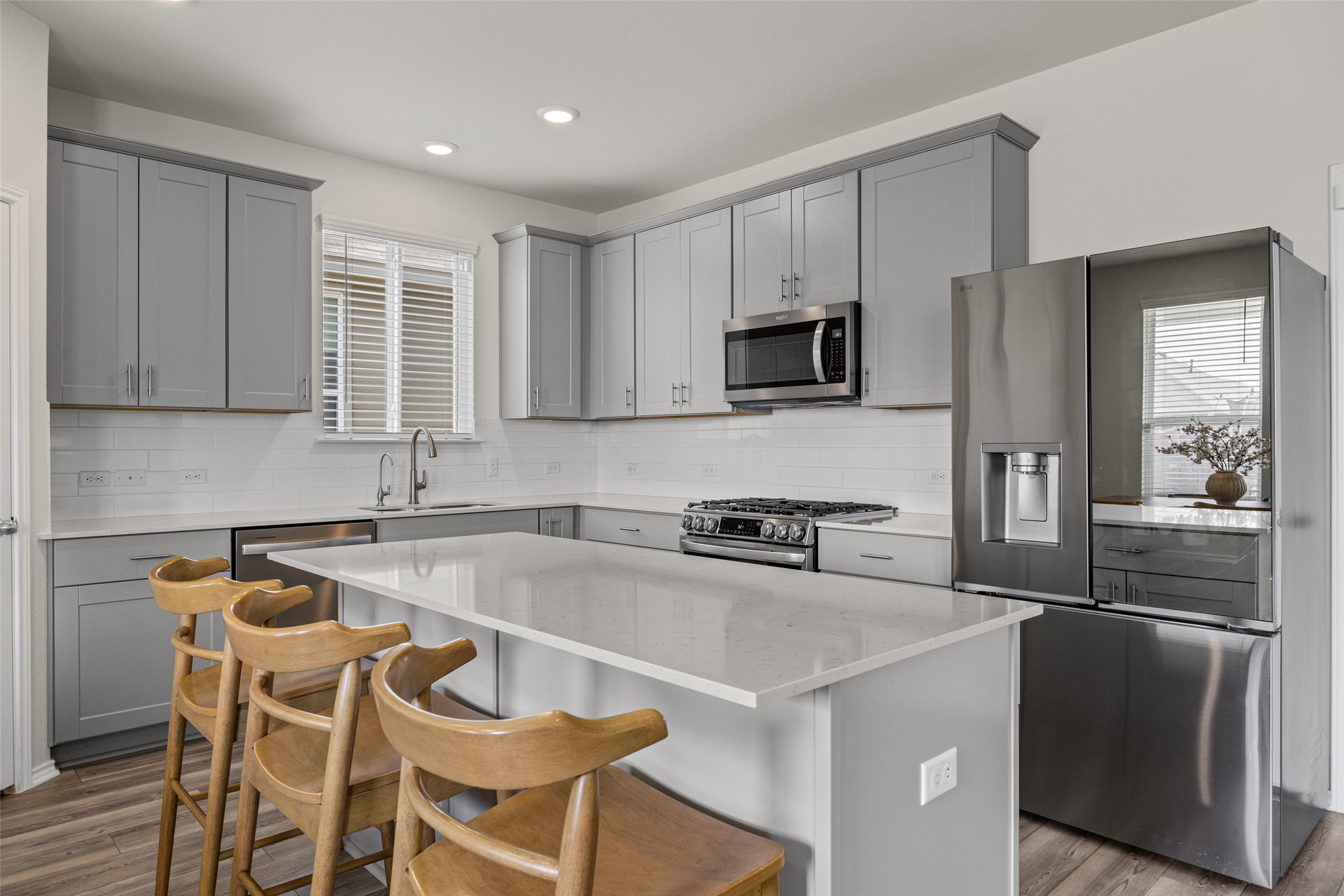 208 Orange Road Buda, TX 78610 - Photo 2 of 31 Prepare culinary delights in this well-appointed kitchen, featuring a central island with bar seating and modern stainless steel appliances.