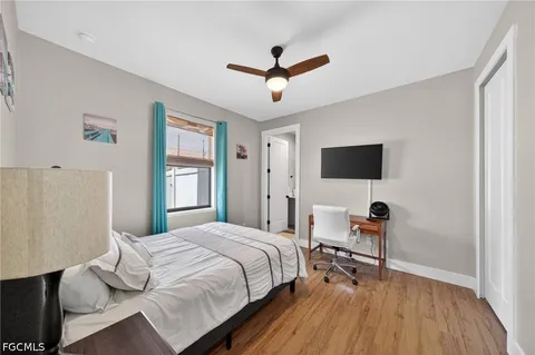 a bedroom with a bed window and a flat screen tv