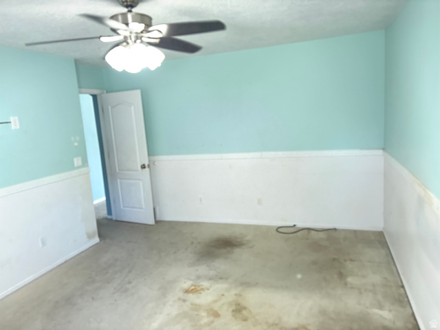 587 West 2400 South Perry, UT 84302 - Photo 24 of 46 Master Bedroom featuring light blue walls with white wainscoting and a ceiling fan with light fixture