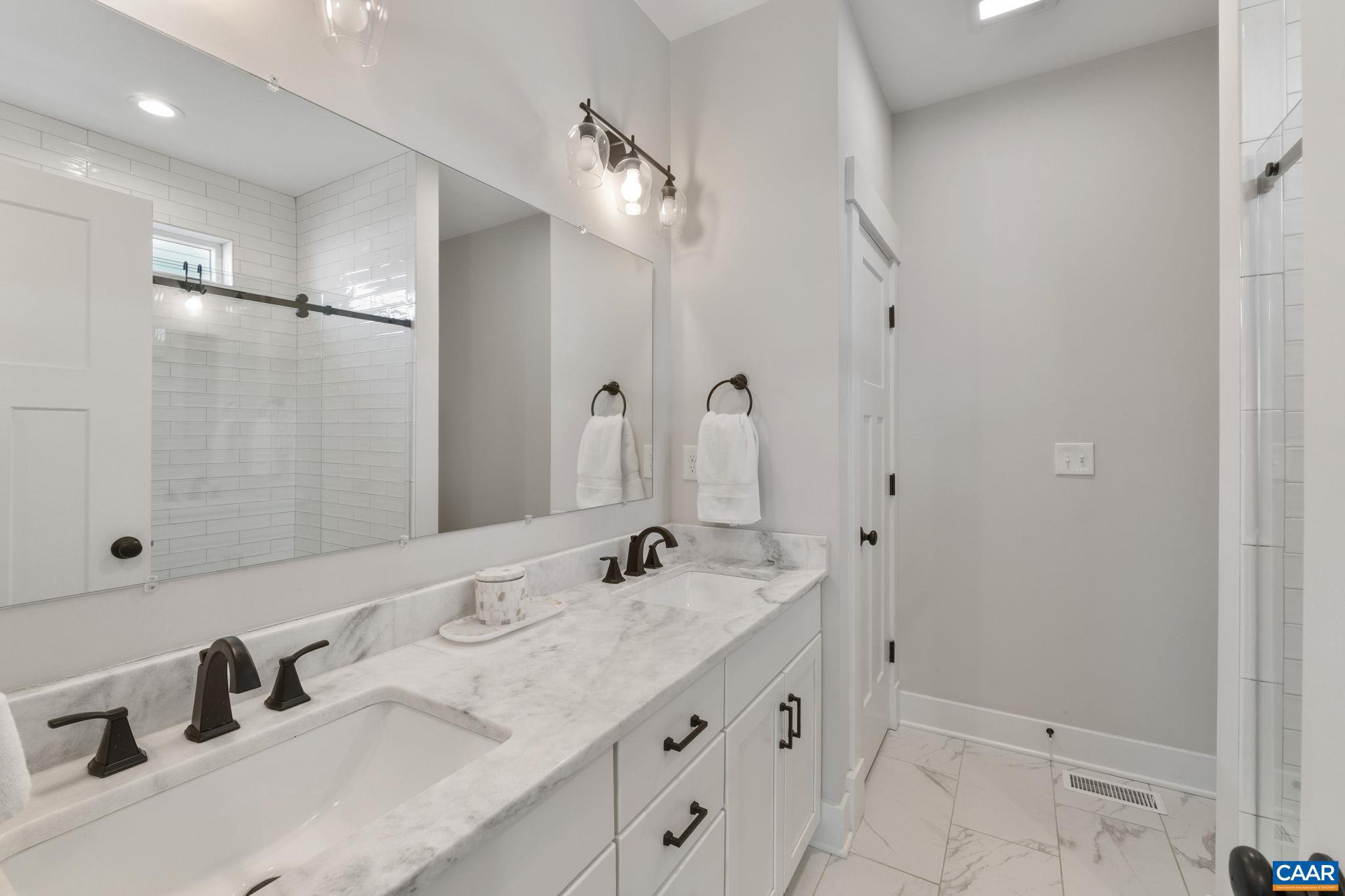 2206 Fowler Street Charlottesville, VA 22901 - Photo 23 of 59 a bathroom with a double vanity sink a mirror and shower