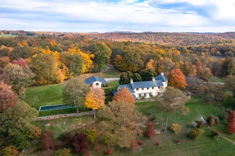 an aerial view of a house with a yard lake view and mountain view in back