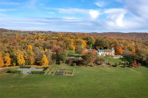 a view of a patio with table and chairs and couches with wooden fence and floor