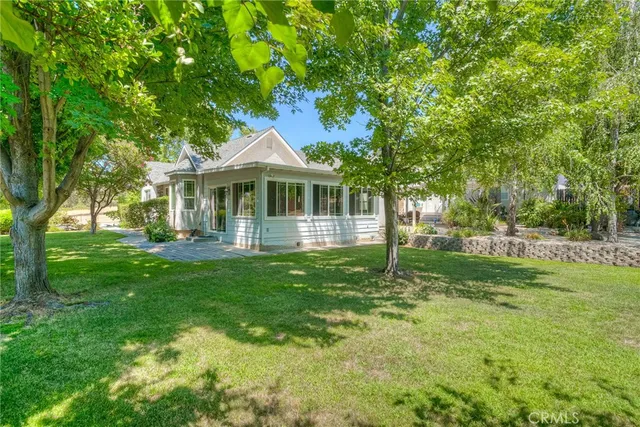 a view of a yard with trees and a wooden fence