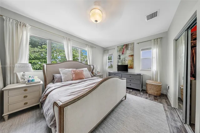 a bedroom with a bed and a large window