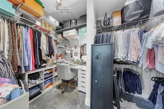 a view of walk in closet with clothes and shoes