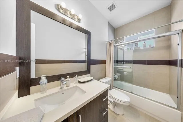 a bathroom with a sink vanity mirror and toilet