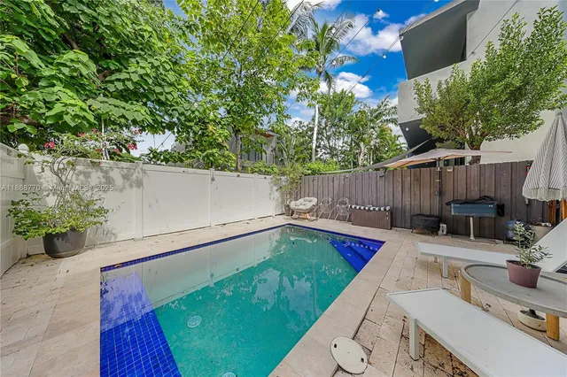 a view of backyard with a tub and potted plants