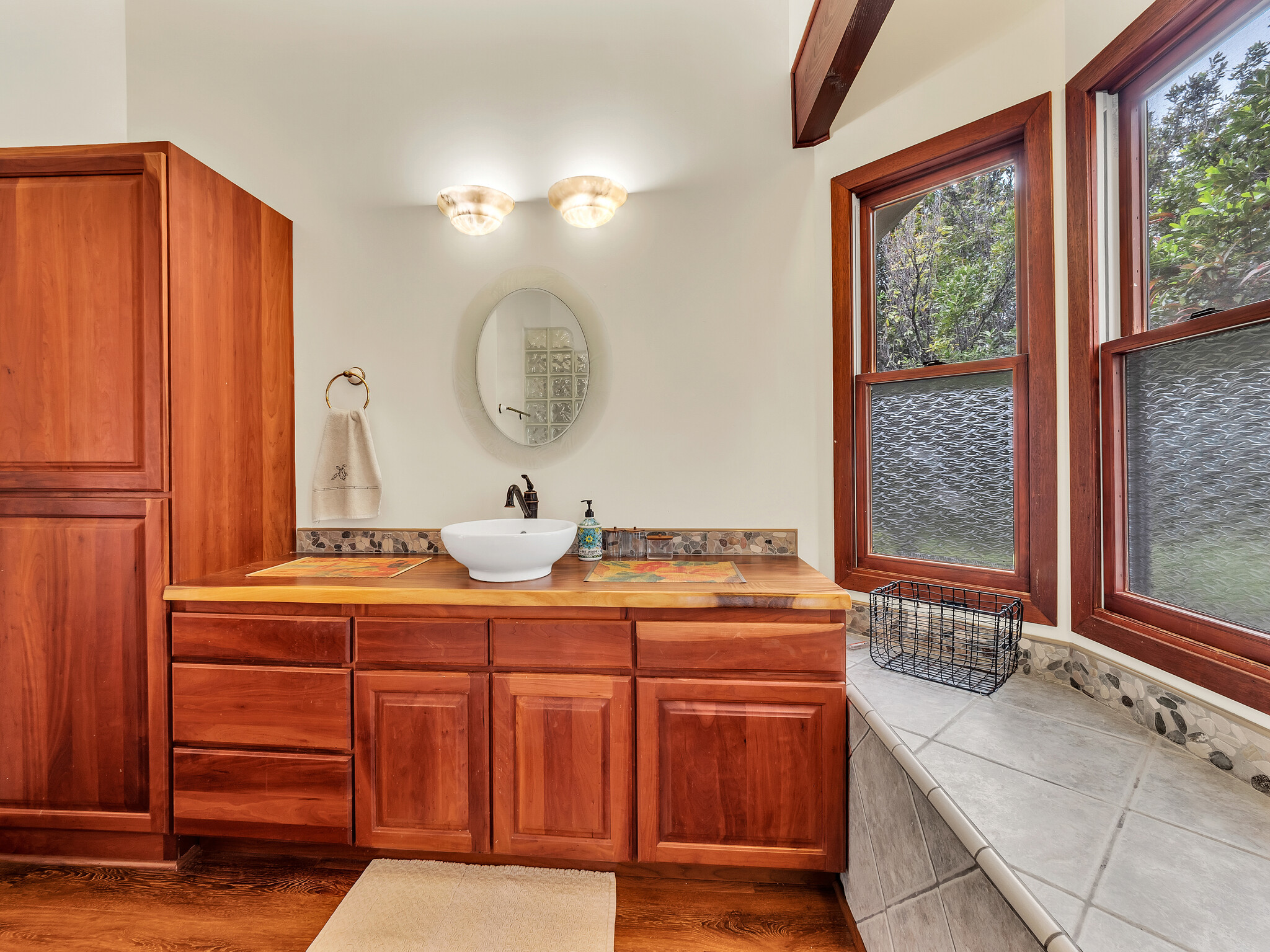 94-1769 Amepela Road Naalehu, HI 96772 - Photo 15 of 29 a bathroom with a granite countertop sink and a mirror