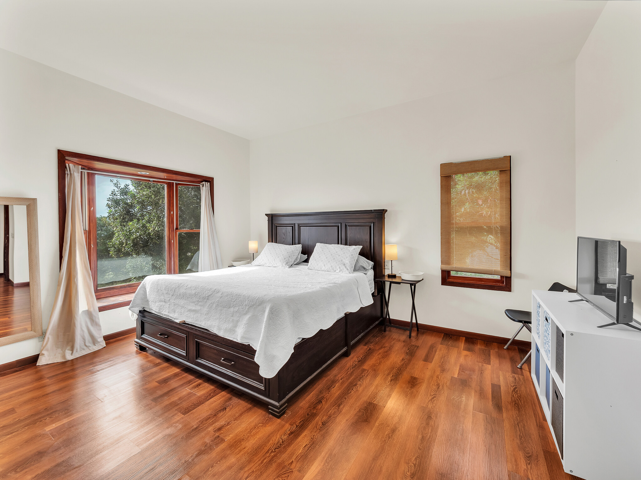 94-1769 Amepela Road Naalehu, HI 96772 - Photo 4 of 29 a spacious bedroom with a bed and wooden floor