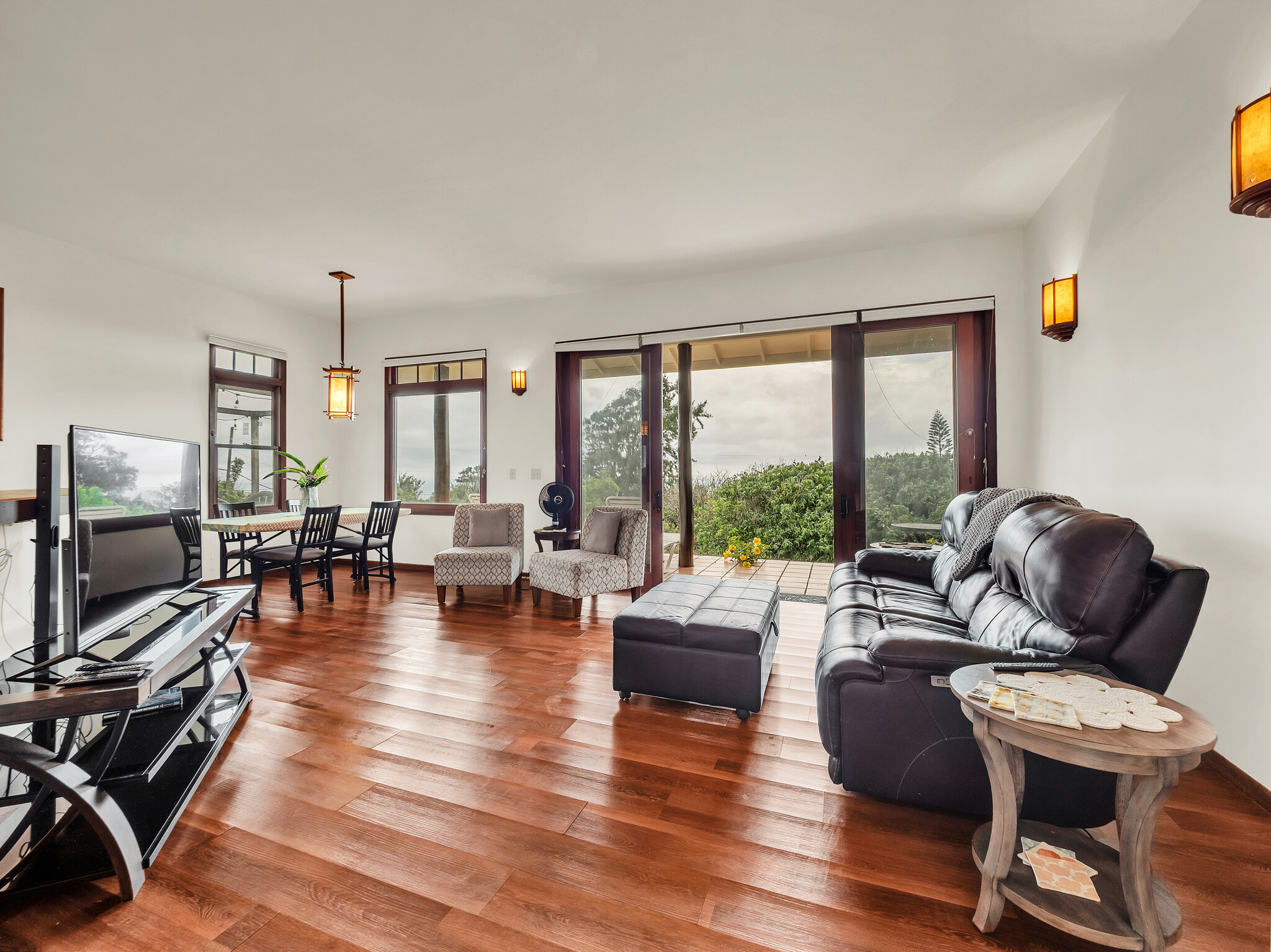 94-1769 Amepela Road Naalehu, HI 96772 - Photo 8 of 29 a living room with furniture floor to ceiling window and a flat screen tv