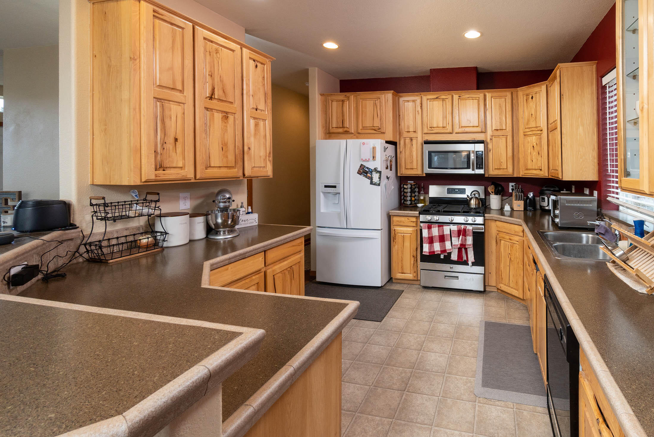 19825 Connarn Road Bend, OR 97703 - Photo 25 of 46 a kitchen with refrigerator a stove a sink a counter top space and cabinets
