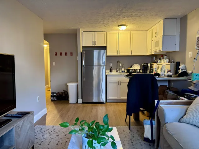 a kitchen with a refrigerator and a stove top oven