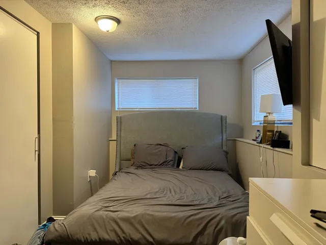 a bedroom with a bed and flat screen tv