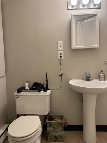 a bathroom with a sink mirror and toilet