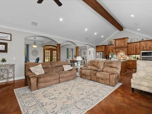 a living room with furniture and a view of kitchen