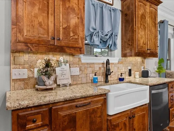 a kitchen with granite countertop a sink a stove and cabinets
