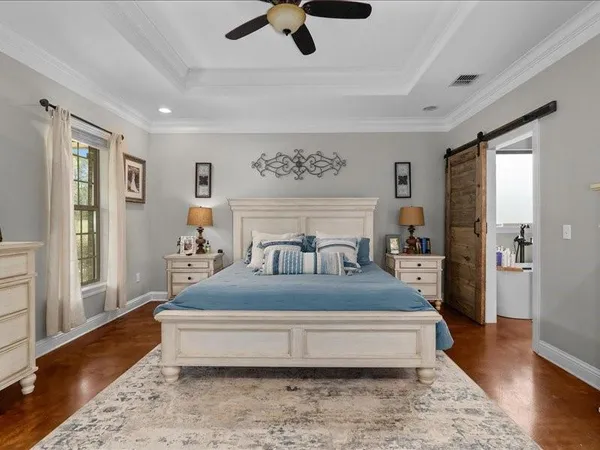 a spacious bedroom with a bed and wooden floor