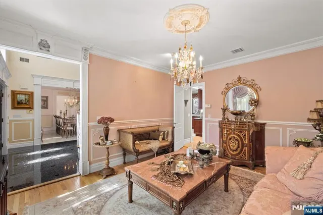 a living room with furniture a chandelier and a fireplace