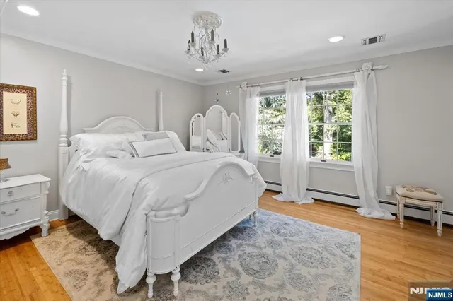 a spacious bedroom with a bed and a chandelier