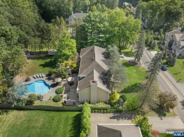 an aerial view of a house with a garden and lake view