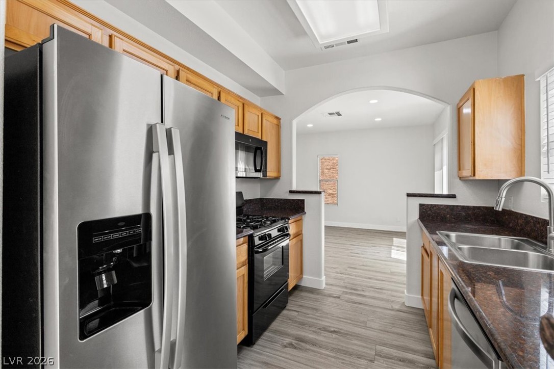 1412 Beaver Spring Street Las Vegas, NV 89128 - Photo 7 of 20 A well-equipped galley kitchen offers ample counter space, rich wood cabinetry, and stainless steel appliances.